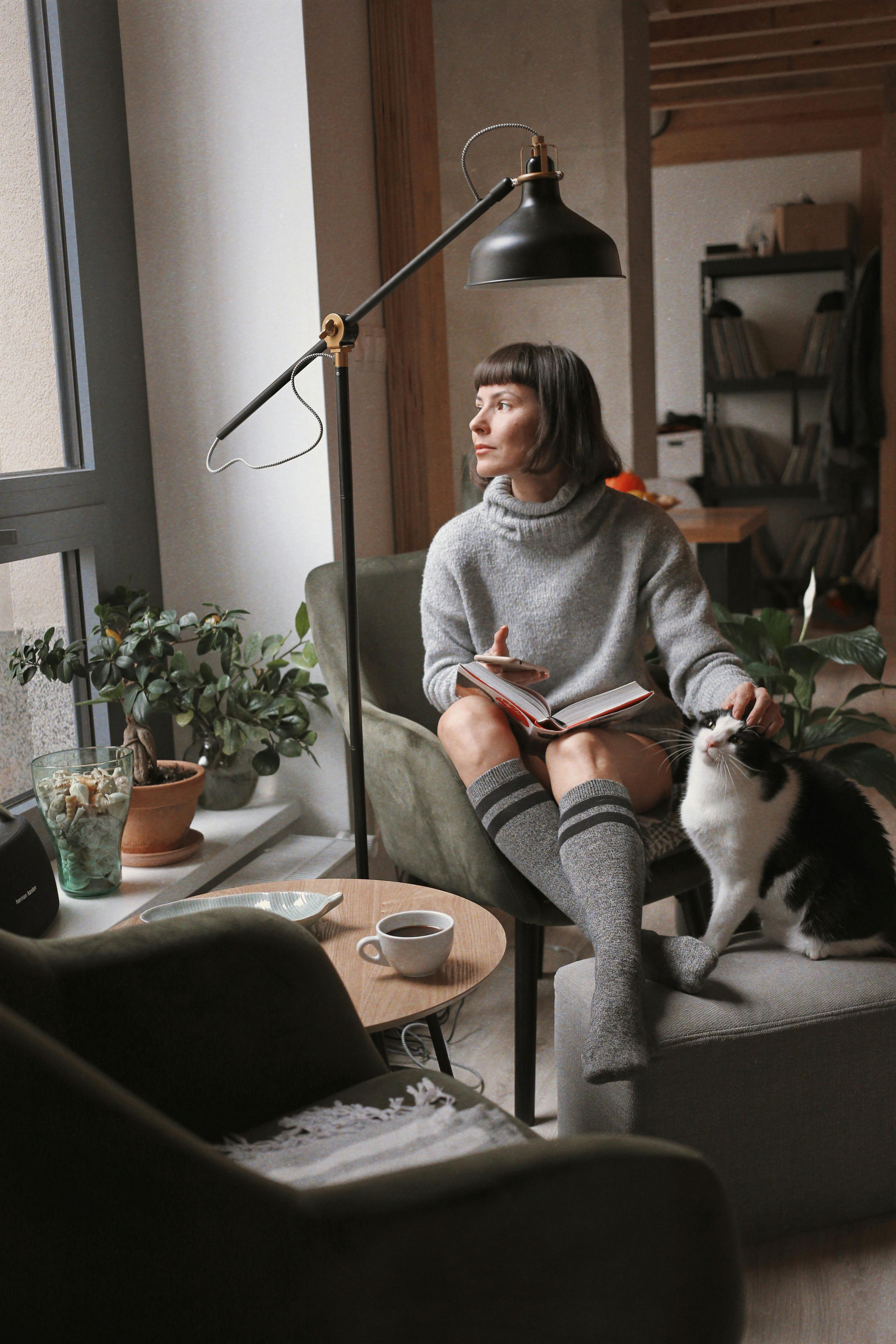 Woman relaxing with cat in cozy indoor setting